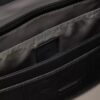 Bolso bandolera con emblema en relieve por toda la superficie