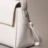 Bolso de hombro con herrajes con el logotipo del emblema y textura de guijarros Bolso de hombro con herrajes con el logotipo del emblema y textura de guijarros