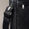 Bolso tipo reporter con logotipo en relieve por toda la superficie