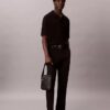 Bolso tipo reporter con logotipo en relieve por toda la superficie