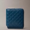 Cartera con cremallera y logotipo en relieve por toda la superficie