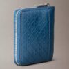 Cartera con cremallera y logotipo en relieve por toda la superficie
