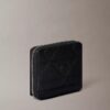 Cartera con cremallera y logotipo en relieve por toda la superficie