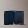 Cartera con cremallera y logotipo en relieve por toda la superficie