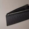 Cartera con cremallera y monogram en relieve por toda la superficie Cartera con cremallera y monogram en relieve por toda la superficie